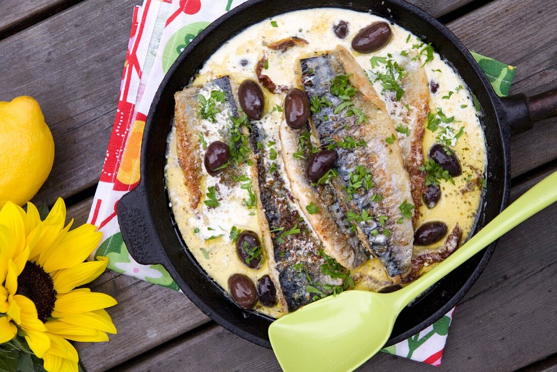 Fried mackerel with cream sauce, black olives and lemon