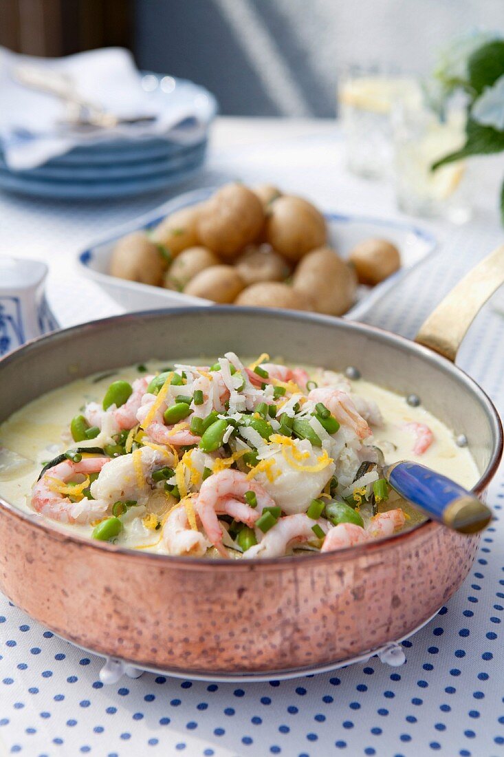 Summer casserole with shrimps, soybeans, chive, lemon and fresh potatoes