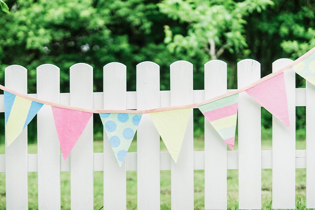 Pastel bunting hung on white picket fence