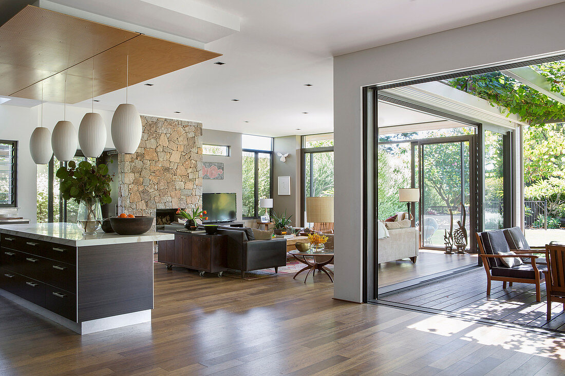 Open living room with window fronts to the garden and terrace