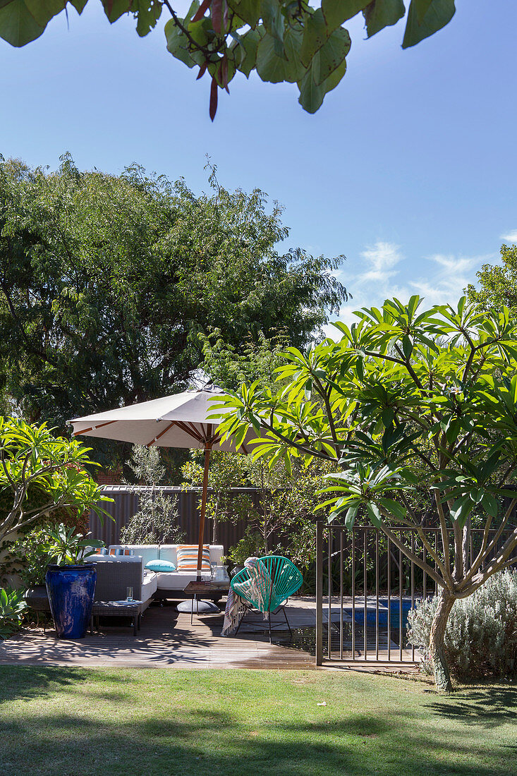 Seating under the parasol in the exotic summer garden