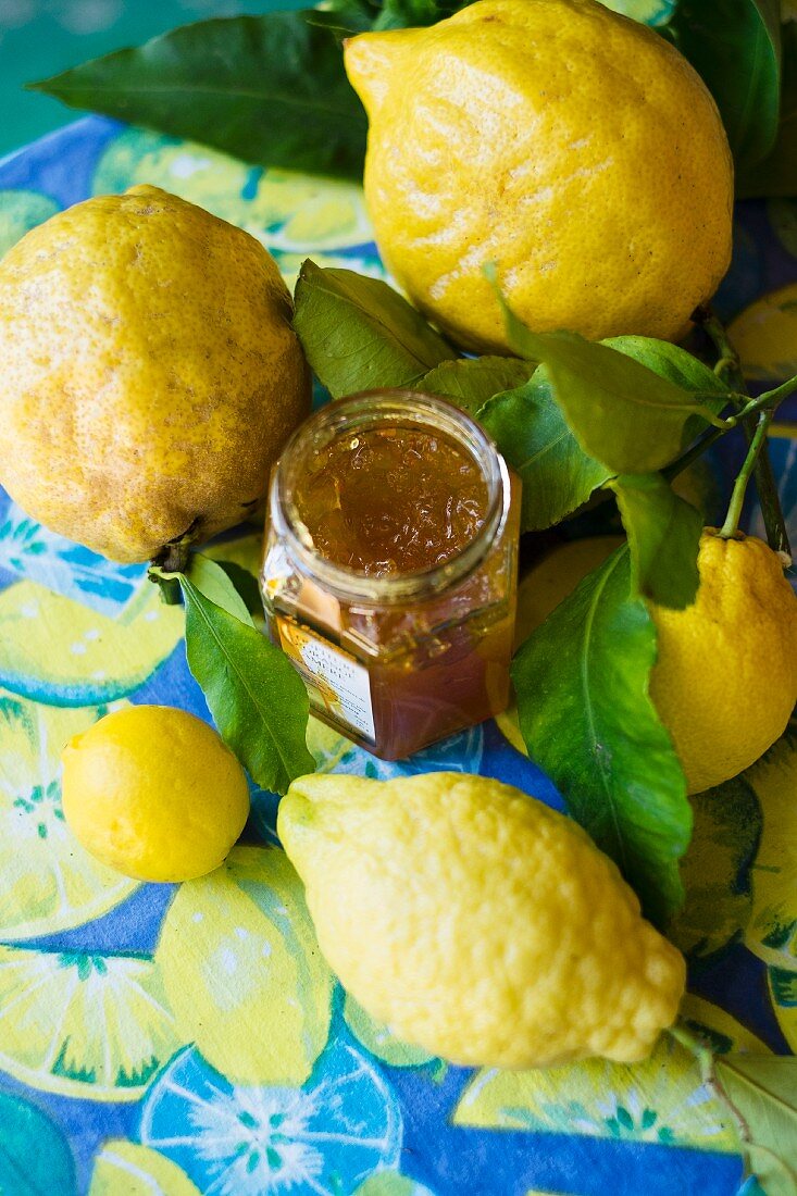 A jar of lemon jam and fresh lemons