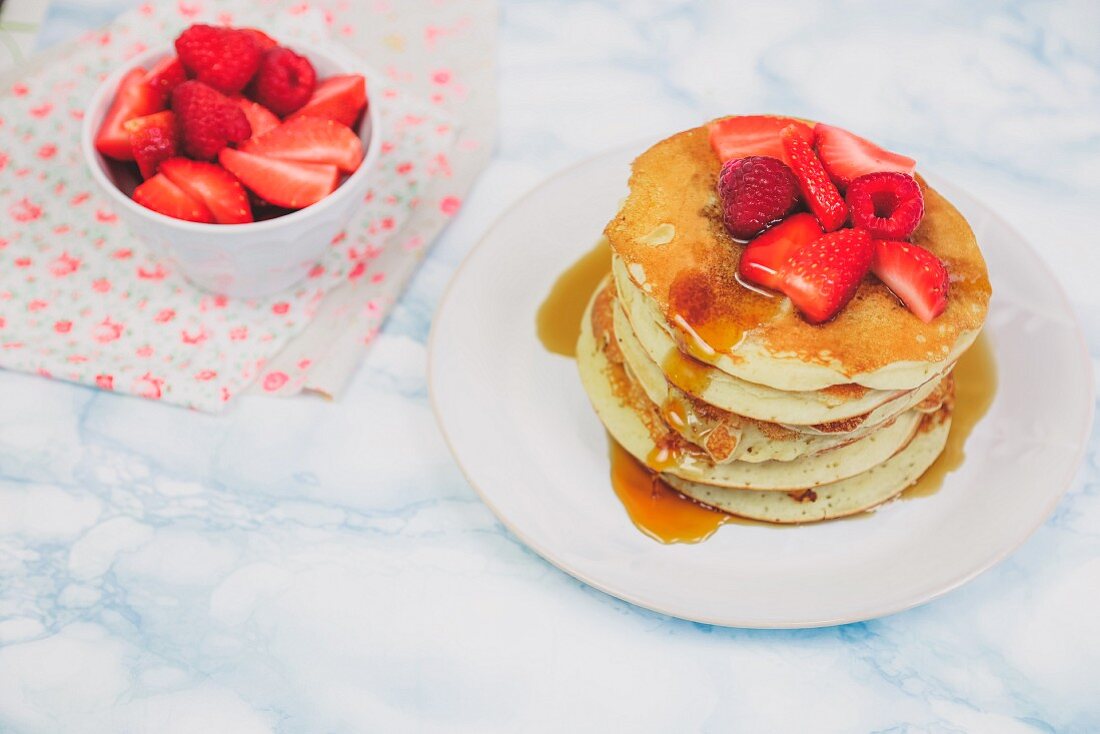 Pancackes with raspberry strawberry and maple syrup