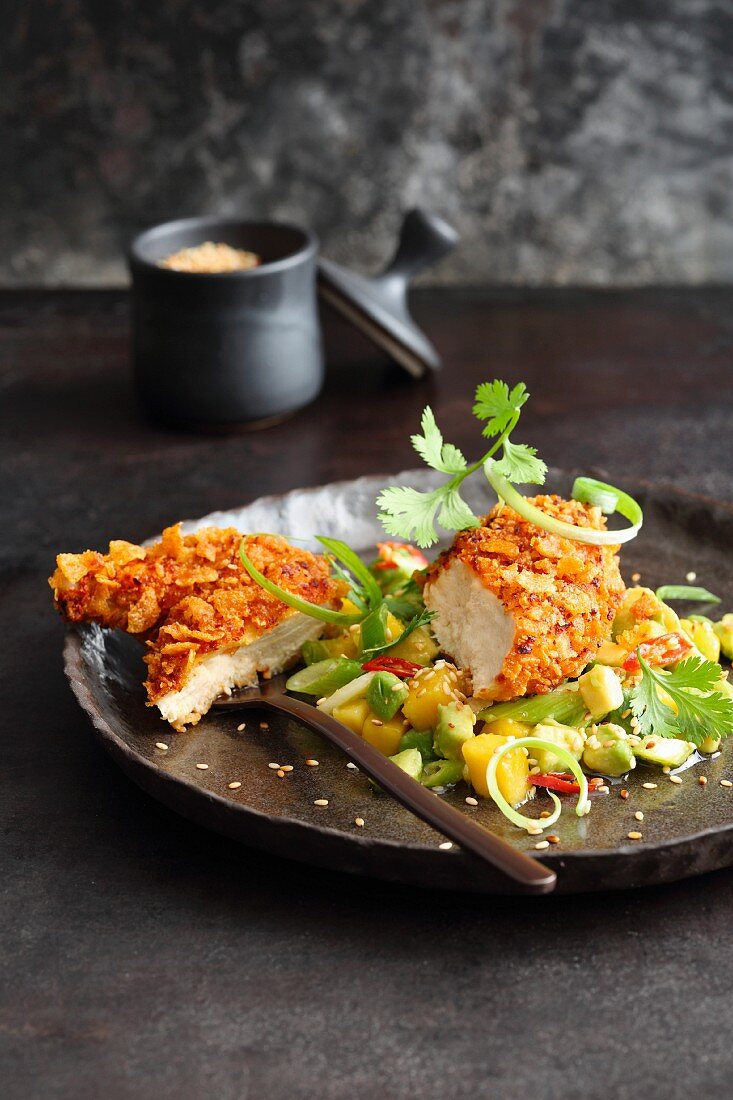 Knuspriges Hühnchen in Cornflakes-Panade auf Avocado-Relish mit Mango