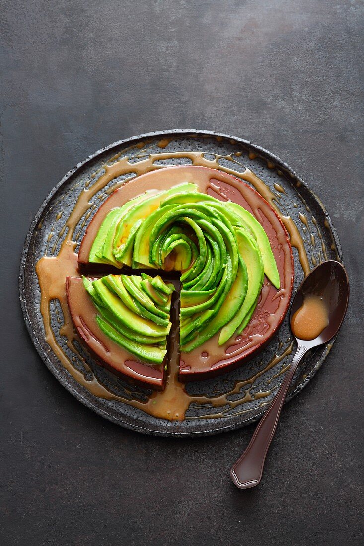 A chocolate and passion fruit cake topped with an avocado rose and caramel and rum syrup