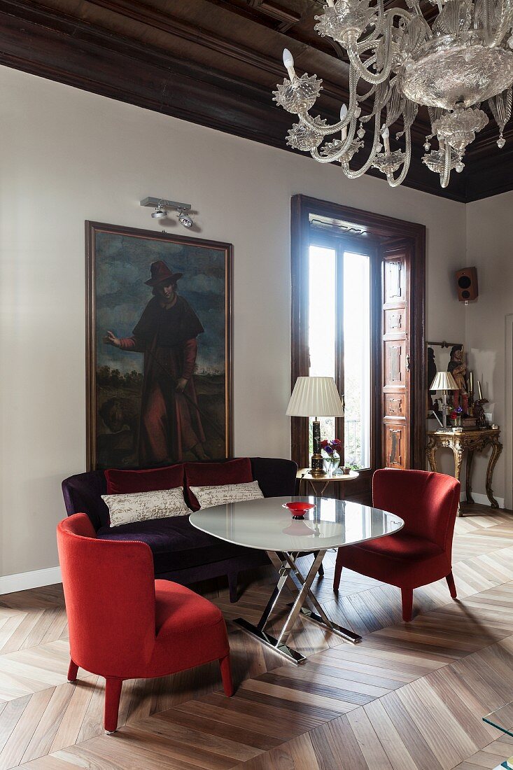 Red armchair and purple sofa flanking modern table