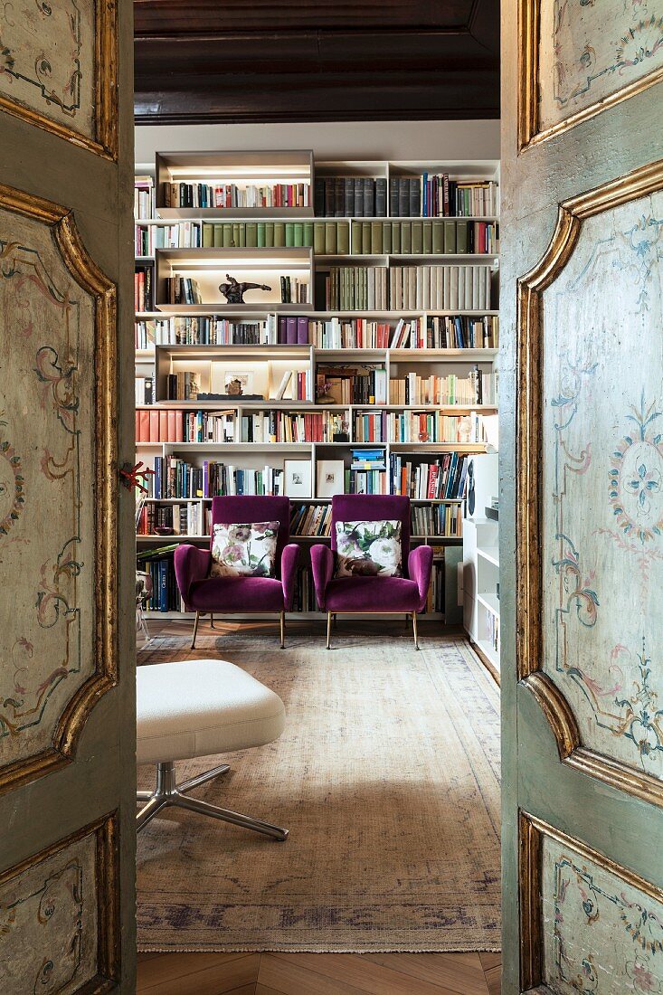 View into library through antique, painted, panelled doors