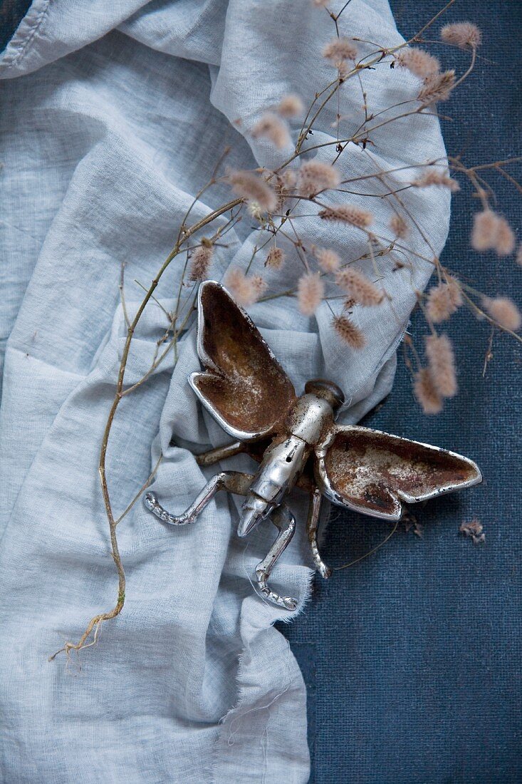 Metal insect figurine on blue fabric