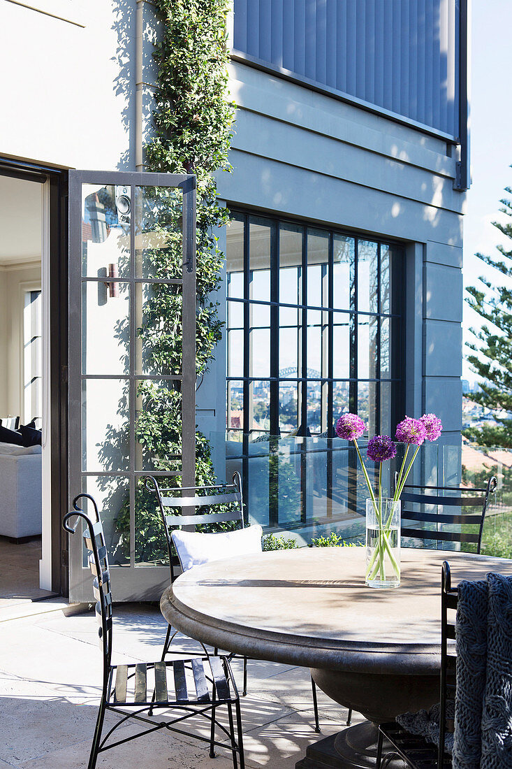 Round garden table with black chairs on the terrace