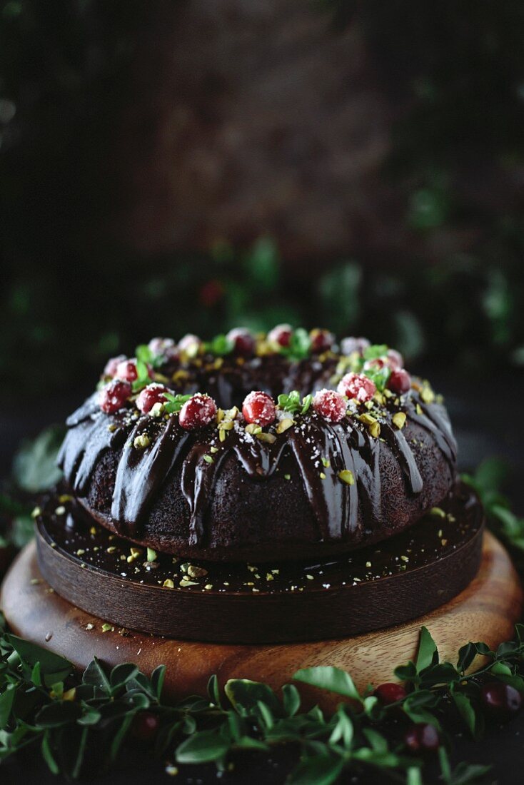 Chocolate bundt cake decorated with pistachios and sugared cranberries