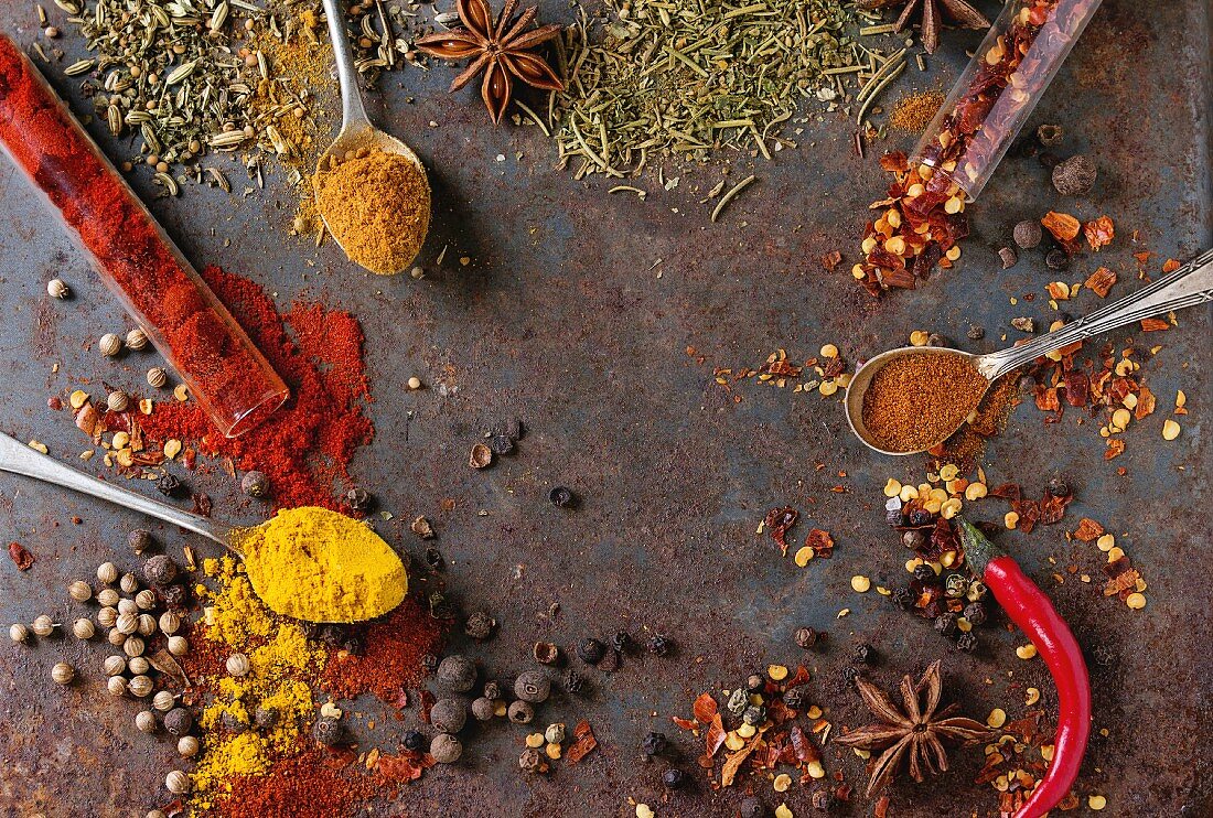 Spicy background with assortment of different hot chili and allspice peppers and mix of other spices