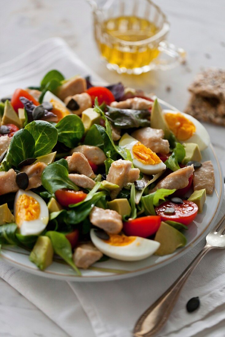 Salat mit Huhn, Avocado, Eiern Tomaten und Feldsalat