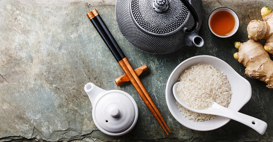 Asiatisches Stillleben mit Teekanne, Ess-Stäbchen, Ingwer und Reis