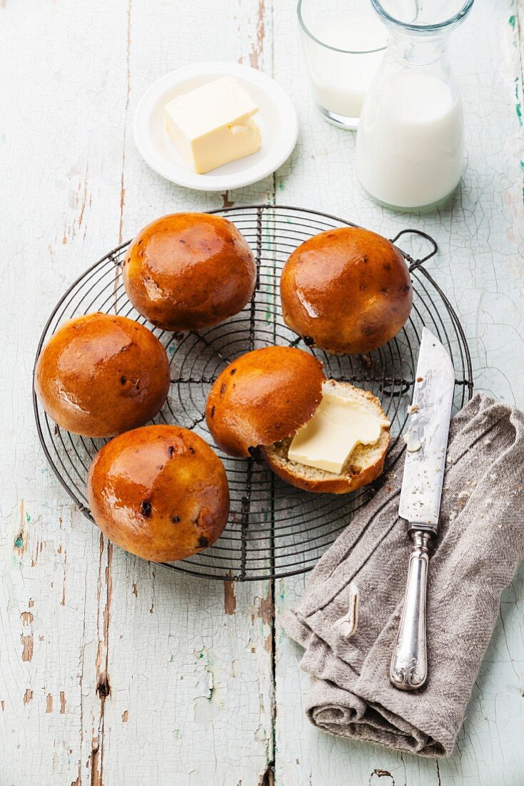 Homemade buns with raisins on Wire Cooling Rack on blue wooden background