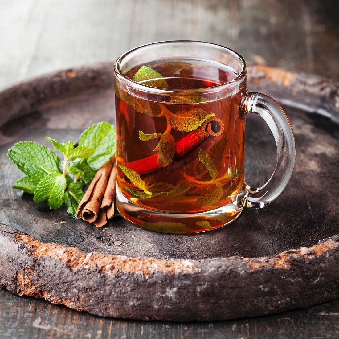 Mint tea with cinnamon on dark background