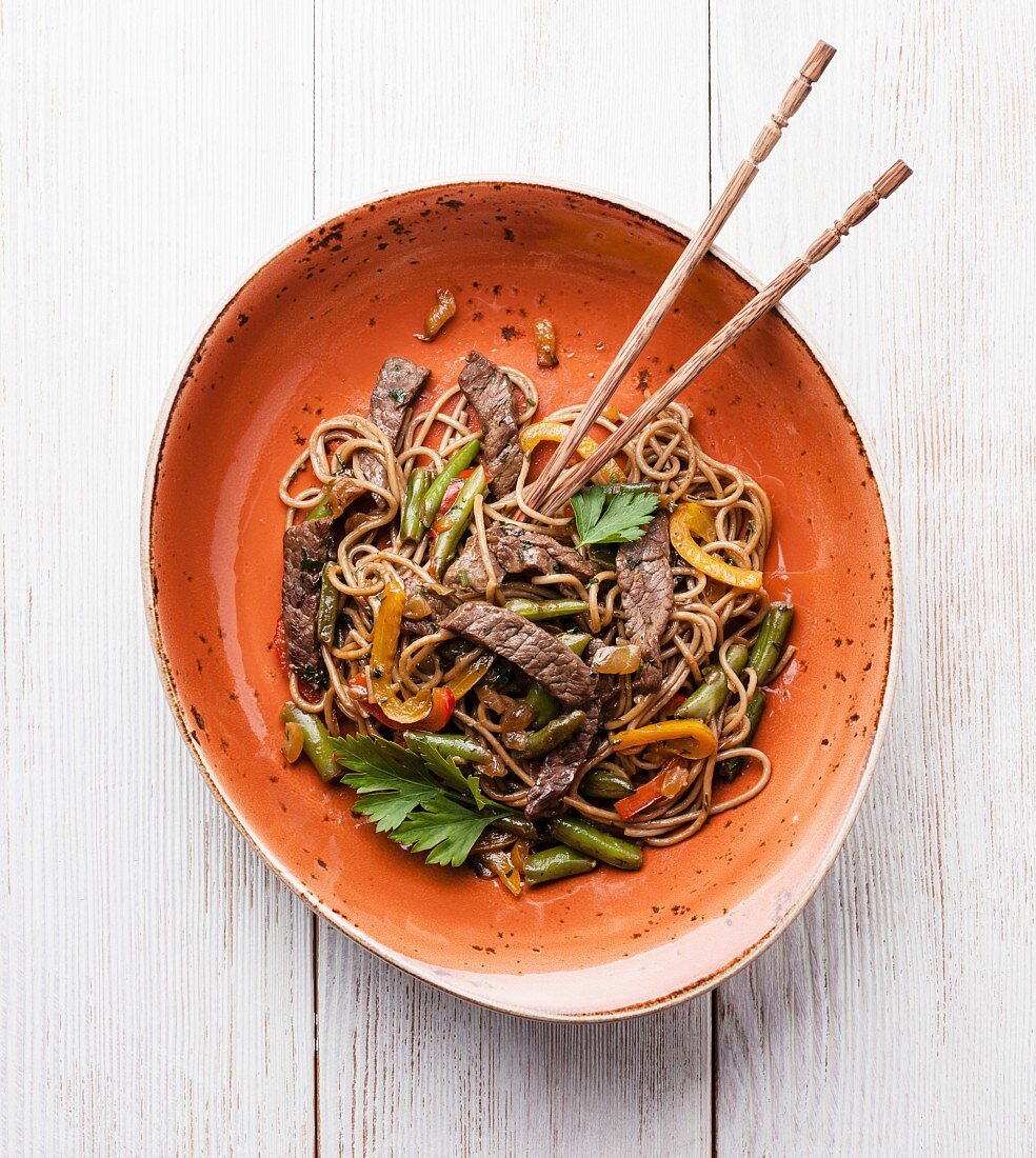 Fried noodles Yakisoba with beef on red plate