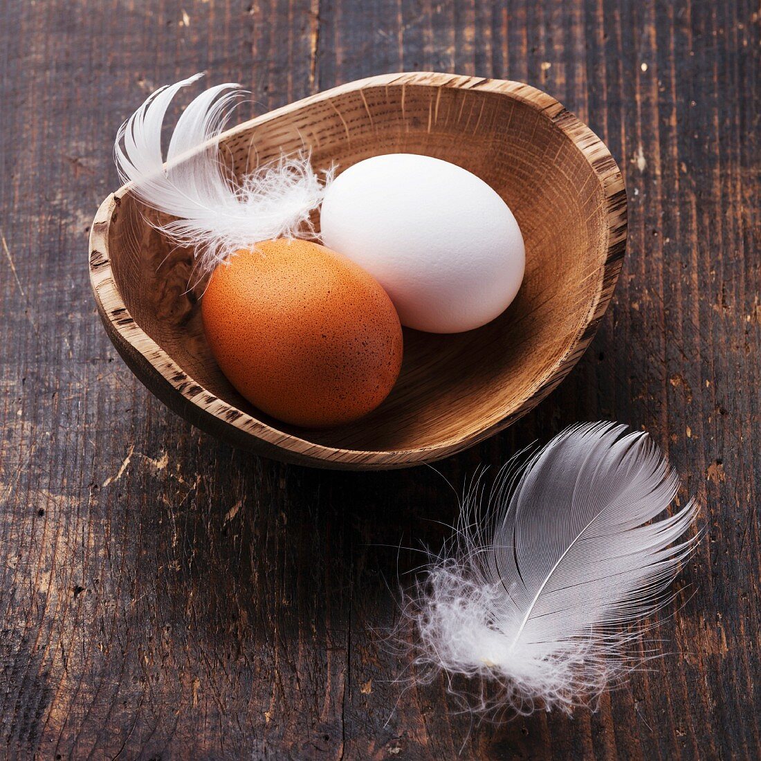 Eggs in bowl on wooden background