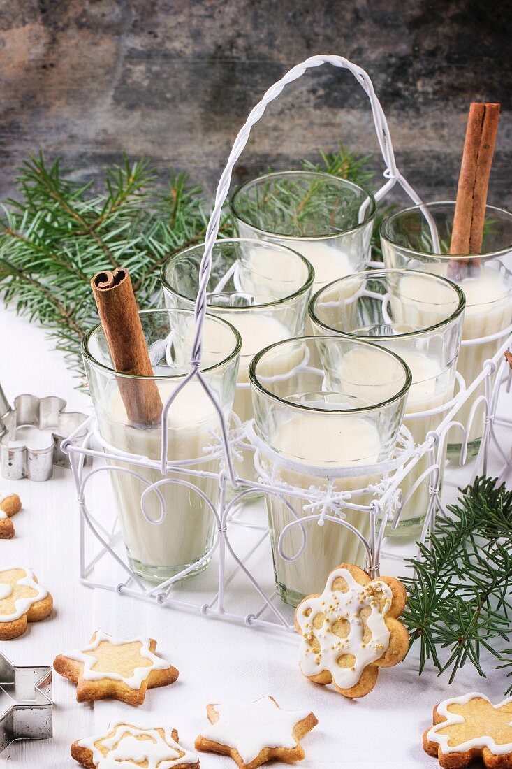 Gläser mit Milch-Cocktail, serviert mit Zimtstangen und Weihnachtsplätzchen