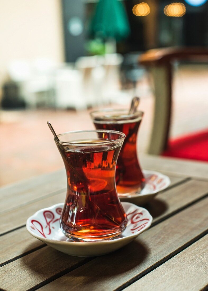 Türkischer Tee in traditionellen Tulpengläsern auf Tisch in Strassencafe