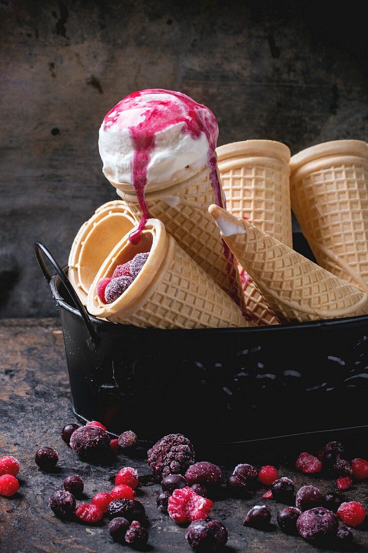 Homemade vanilla ice cream in wafer cones and empty waffer cones