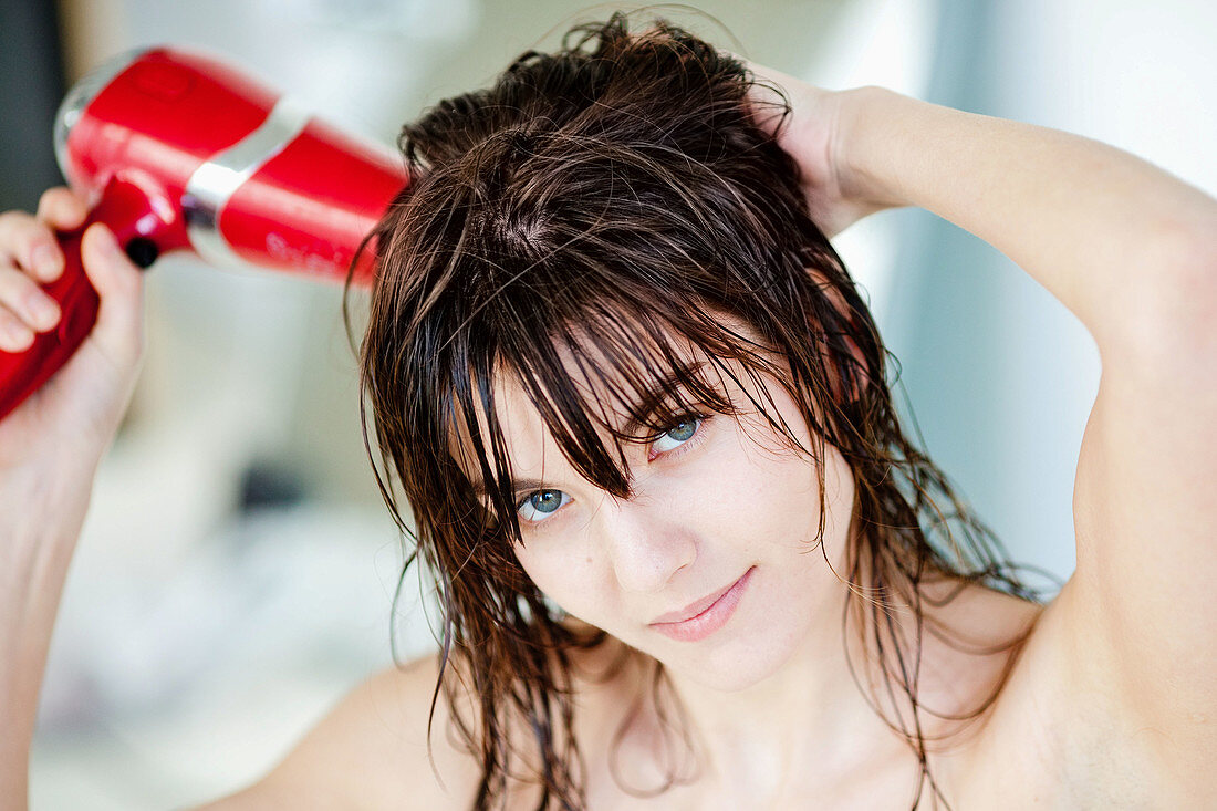 Woman using hair dryer