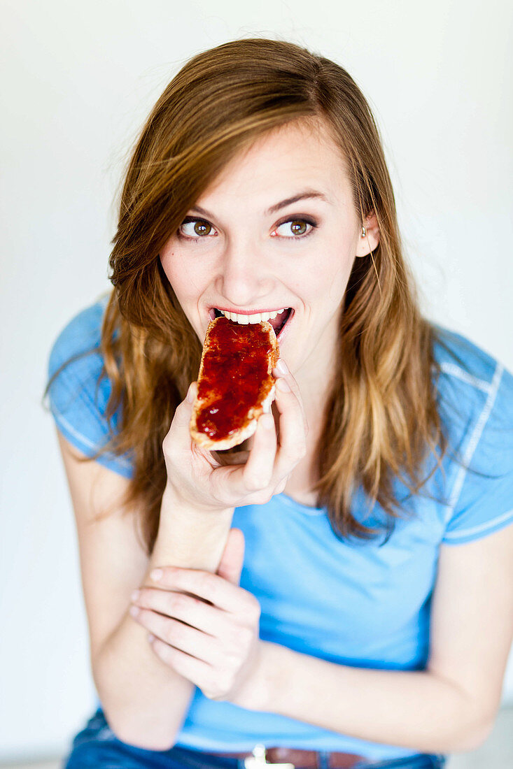 Woman eating a jam toast
