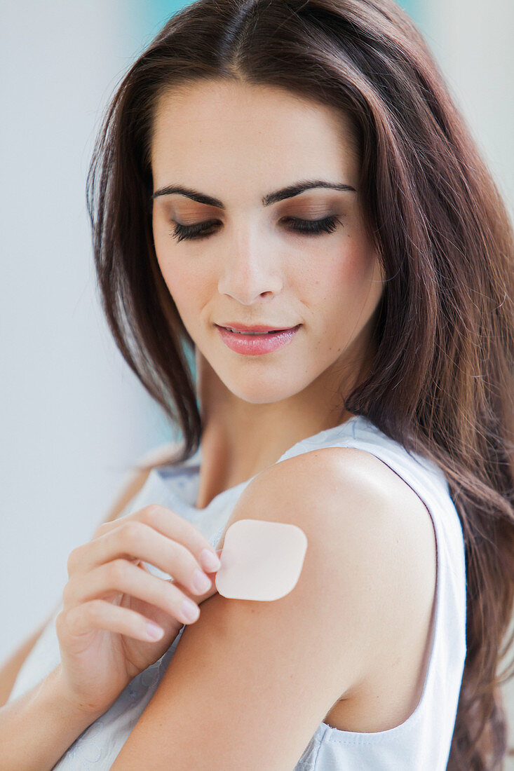 Woman applying a patch