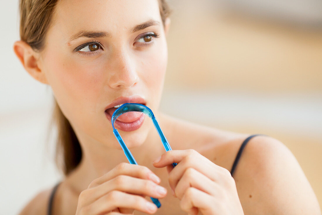Woman brushing her tongue