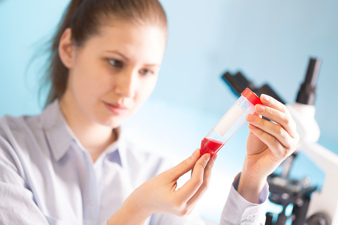 Woman holding blood sample in test tube