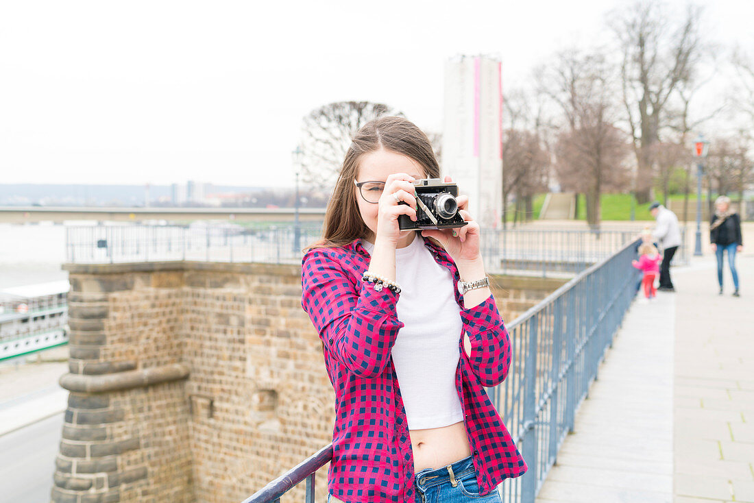 Young woman taking photo with camera