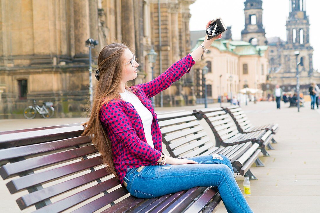 Young woman taking photo of herself with camera