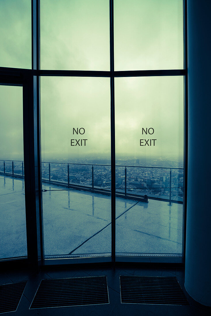 Glass doors with 'no entry' and view of city