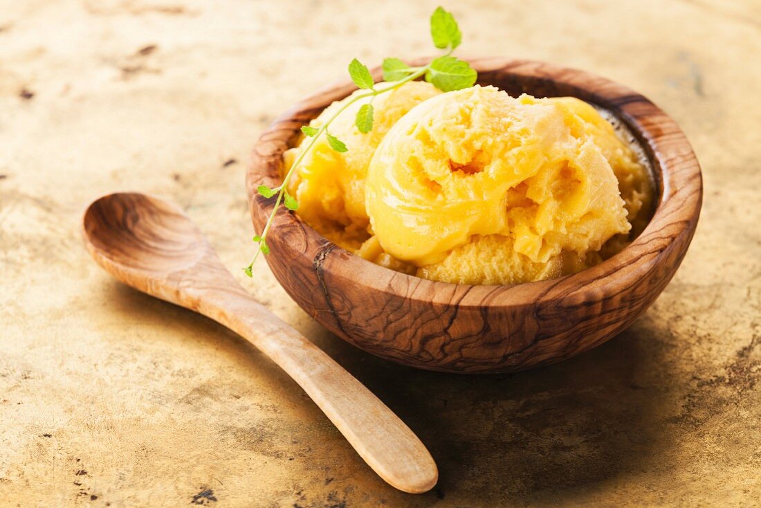 Mango ice cream sorbet in olive wood bowl