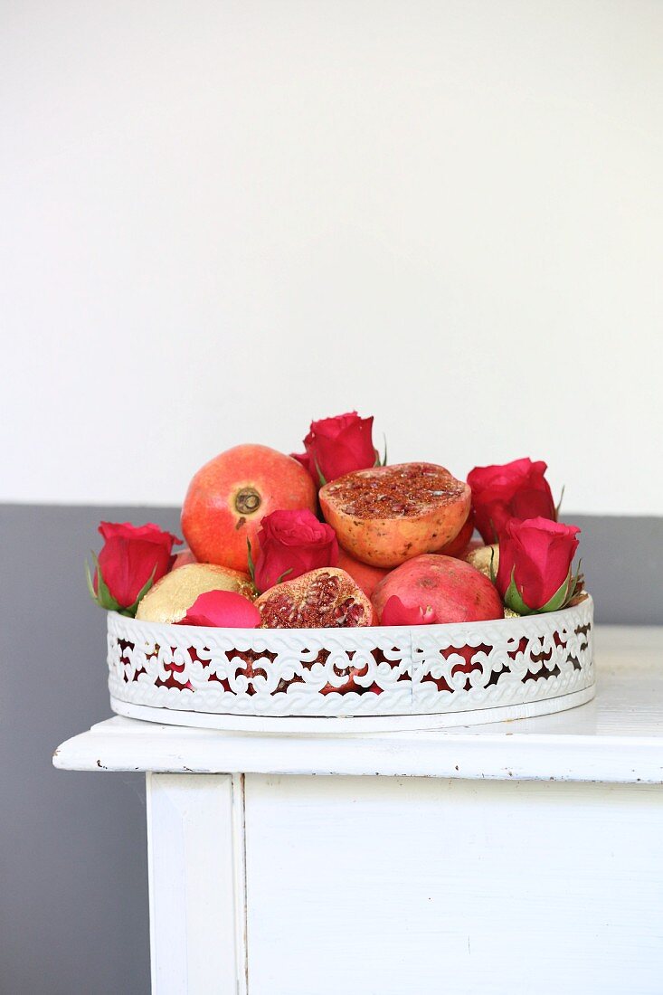 Granatäpfel und Rosenblüten auf Vintage Tablett