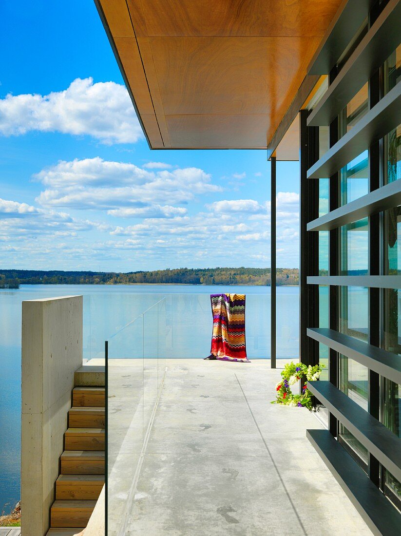 Terrasse mit Betonboden, Glasbrüstung und Seeblick