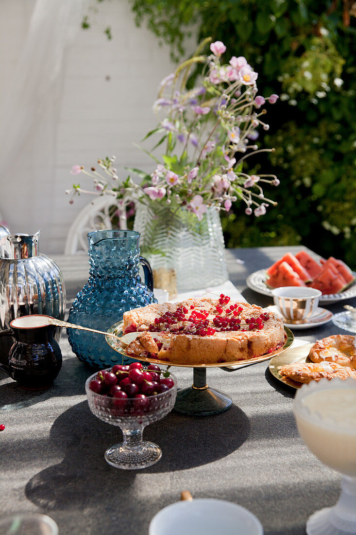 Johannisbeerkuchen auf gedecktem Gartentisch im Sommer