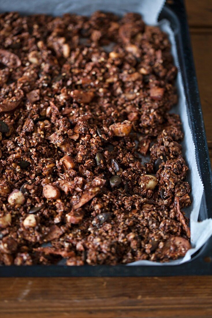 Selbst gemachtes Schokoladenmüsli mit Samen, Nüssen auf einem Backblech