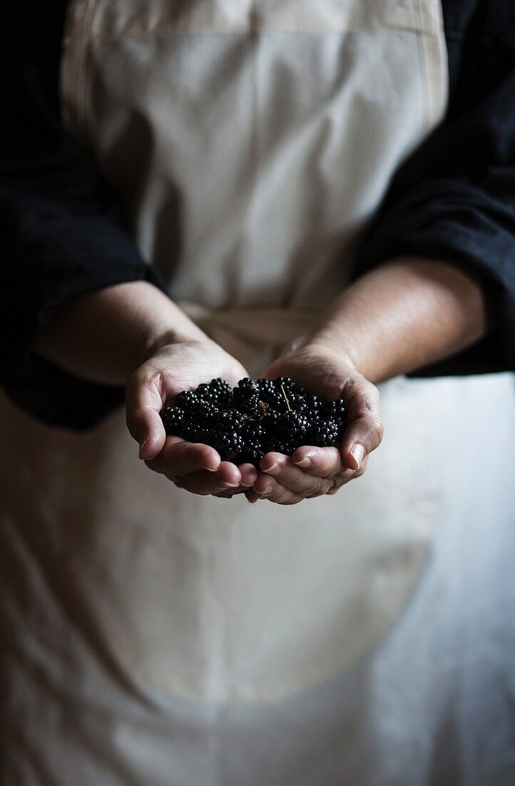 Frau hält frische Brombeeren in den Händen