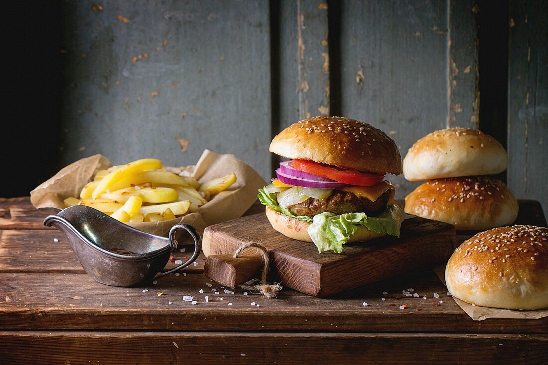 Selbstgemachte Burger mit Pommes und Ketchup auf Holzuntergrund