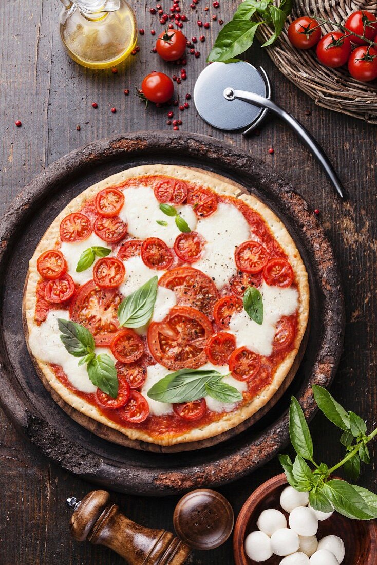 Pizza mit Tomaten, Mozzarella und Basilikum