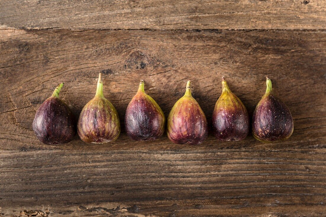 Row of fresh figs on a wooden table