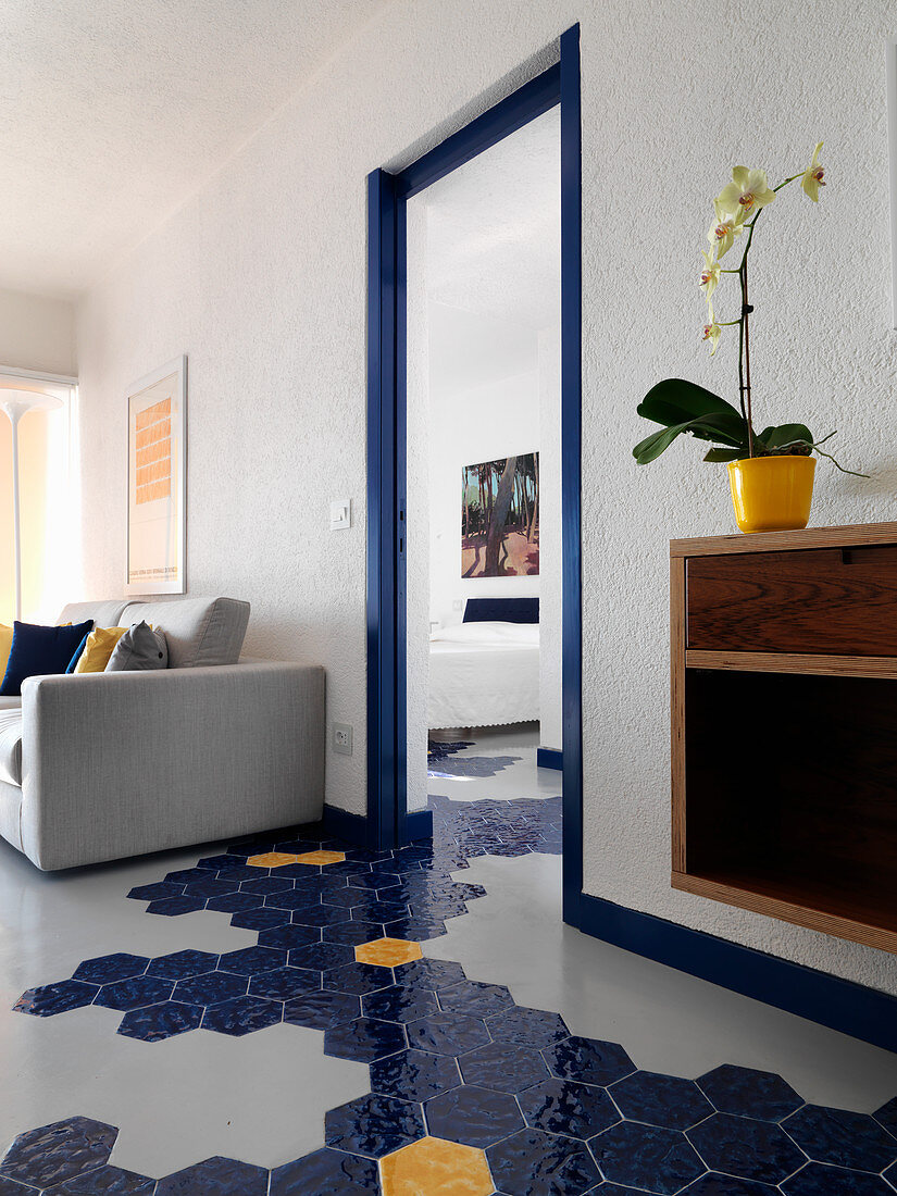 Grey concrete floor with hexagonal tiles running through multiple rooms