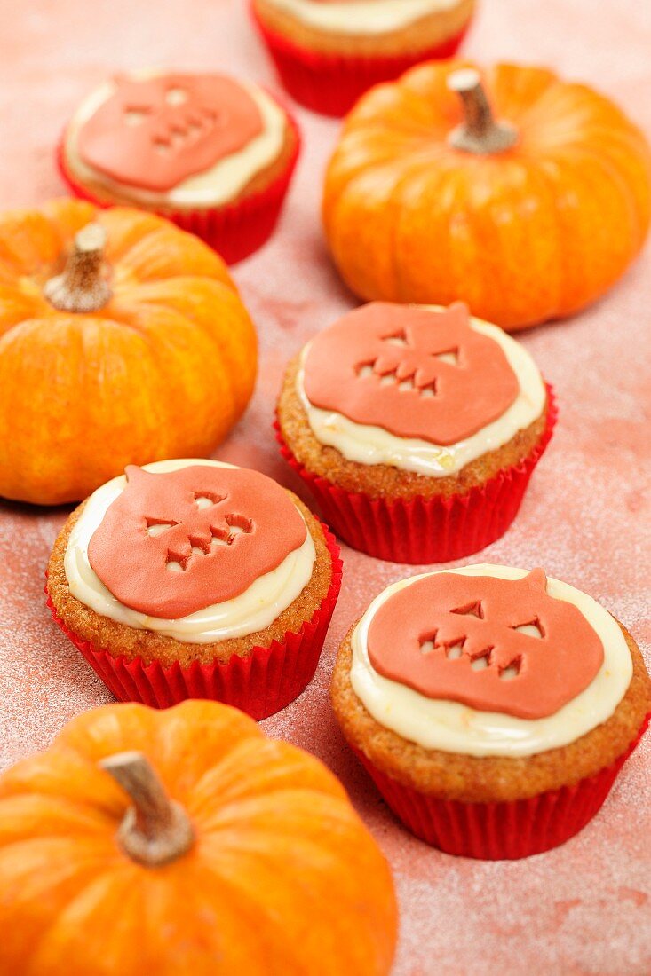 Mehrere Cupcakes mit Kürbisdeko zu Halloween