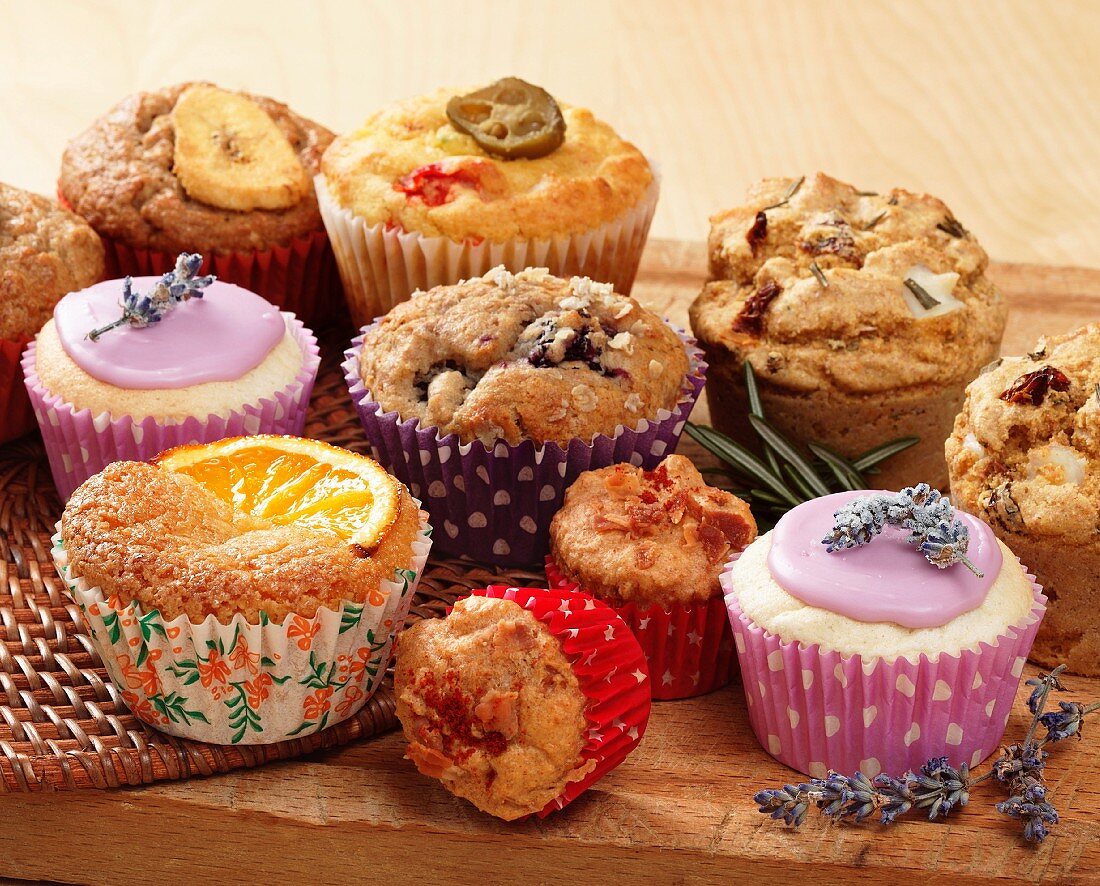 A selection of muffins and cupcakes on a wooden board