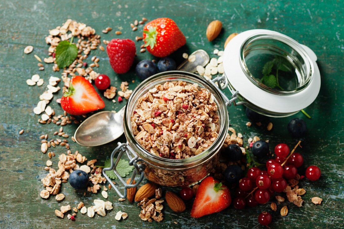Healthy breakfast of muesli, berries with yogurt and seeds on dark background
