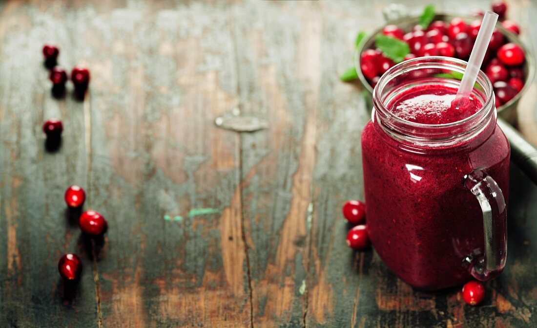 Cranberry smoothie on rustic wooden background