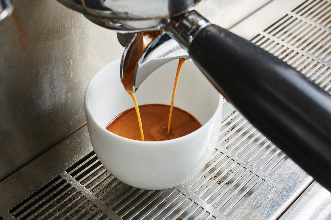 Kaffee fliesst aus Kaffeemaschine