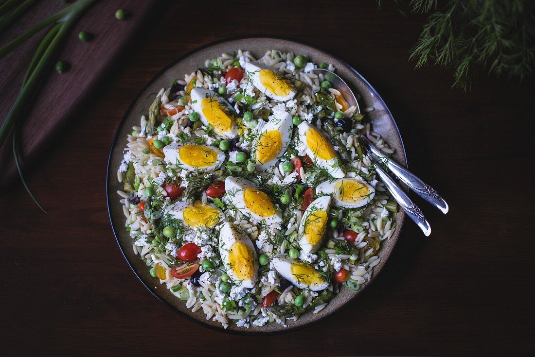 A large bowl of Mediterranean-Style Orzo Salad with Spring Vegetables