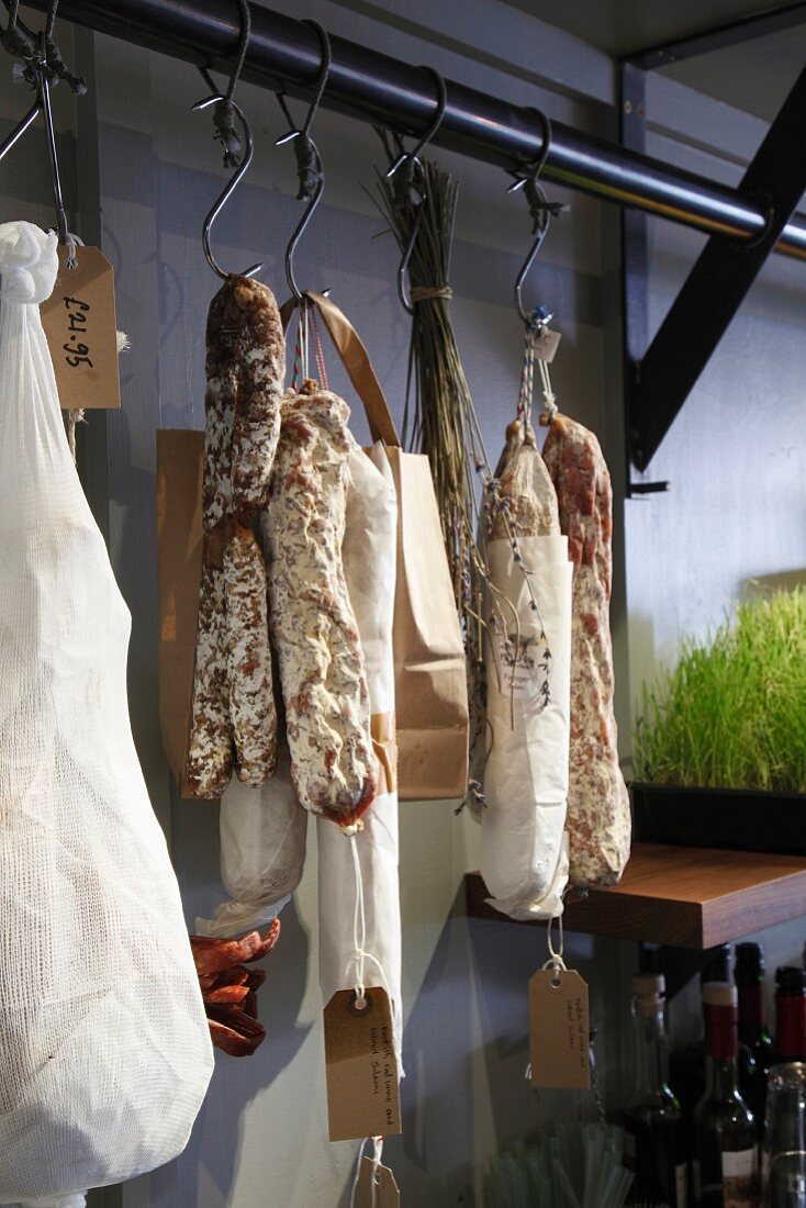 Charcuterie hanging from meat hooks in a butcher's
