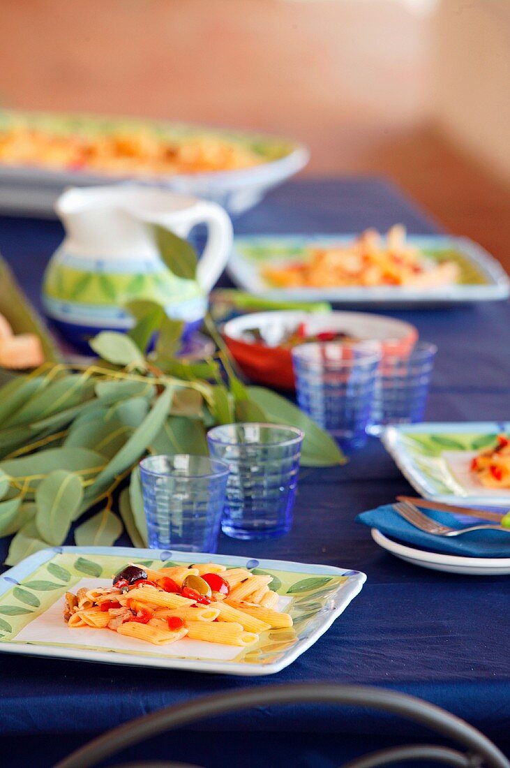 Penne pasta with tomatoes on blue table